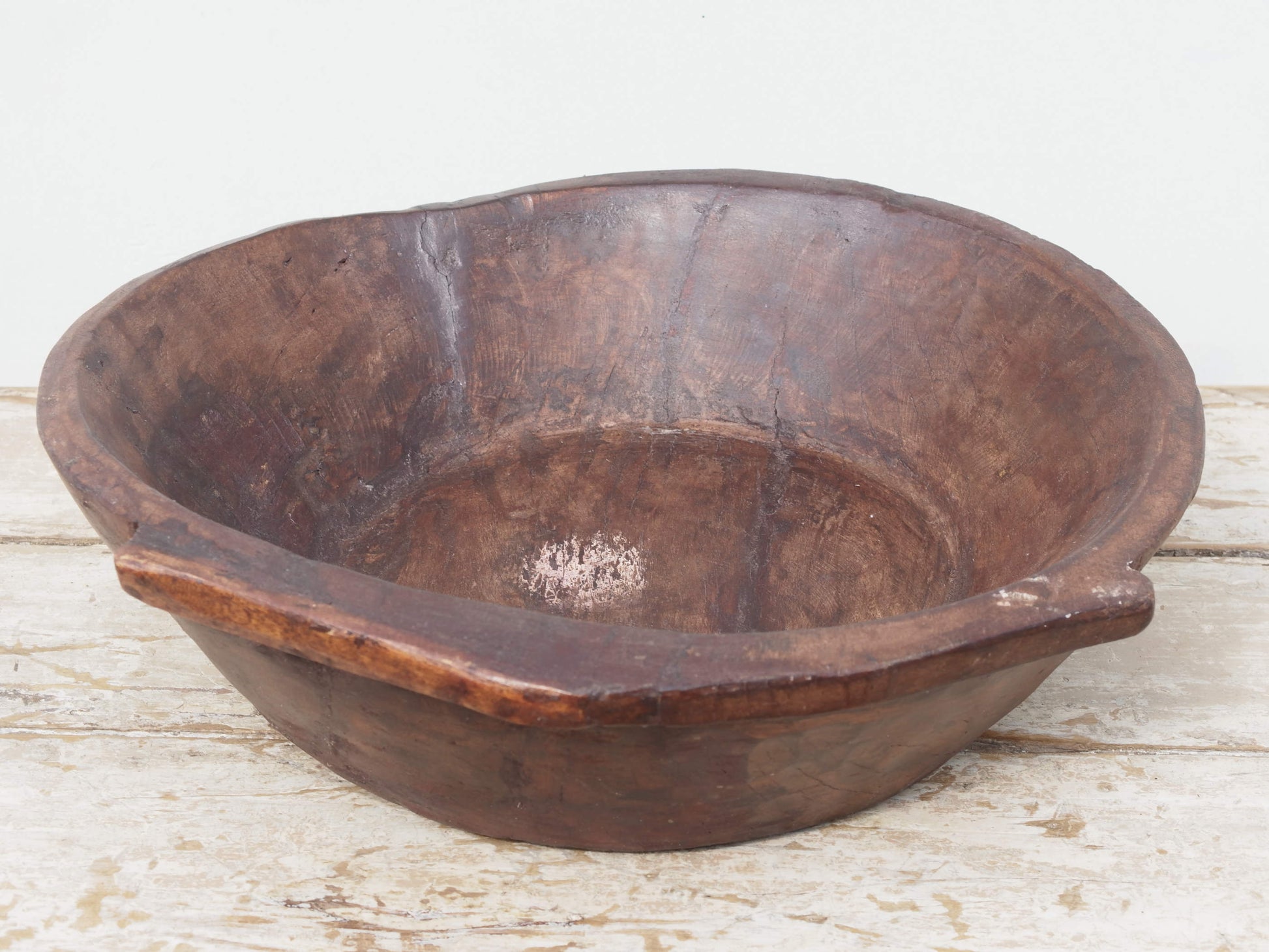 piatto in legno ricavato da un unico tronco di legno. usato in principio come piatto, setaccio per esiccare i cereali. tronco unico di teak massello databile inizio / metà 900.  dimensioni 49X47 h 13cm.