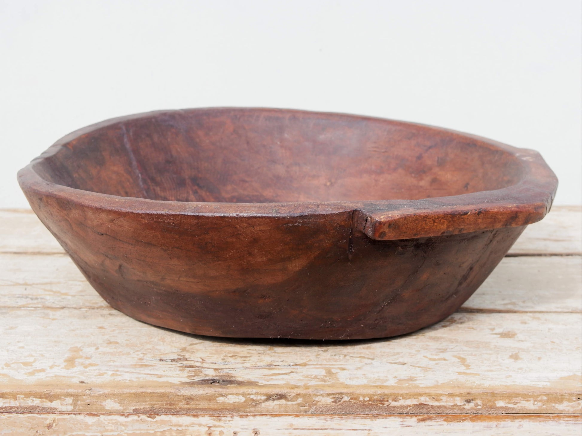 piatto in legno ricavato da un unico tronco di legno. usato in principio come piatto, setaccio per esiccare i cereali. tronco unico di teak massello databile inizio / metà 900.  dimensioni 49X47 h 13cm.