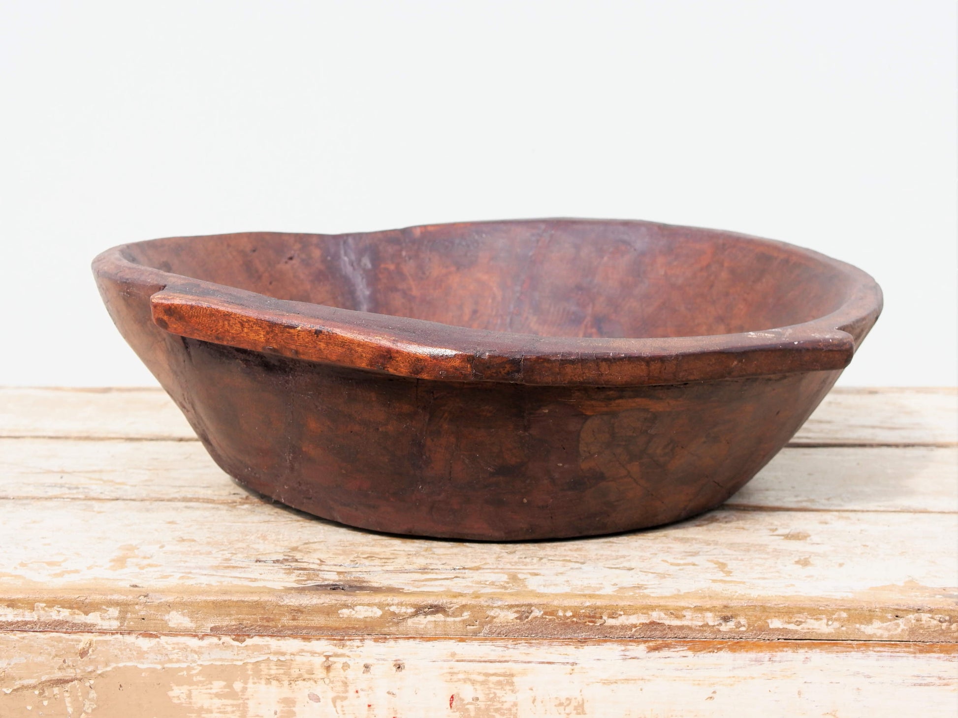 piatto in legno ricavato da un unico tronco di legno. usato in principio come piatto, setaccio per esiccare i cereali. tronco unico di teak massello databile inizio / metà 900.  dimensioni 49X47 h 13cm.