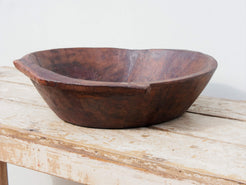 piatto in legno ricavato da un unico tronco di legno. usato in principio come piatto, setaccio per esiccare i cereali. tronco unico di teak massello databile inizio / metà 900.  dimensioni 49X47 h 13cm.