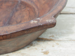 piatto in legno ricavato da un unico tronco di legno. usato in principio come piatto, setaccio per esiccare i cereali. tronco unico di teak massello databile inizio / metà 900.  dimensioni 49X47 h 13cm.