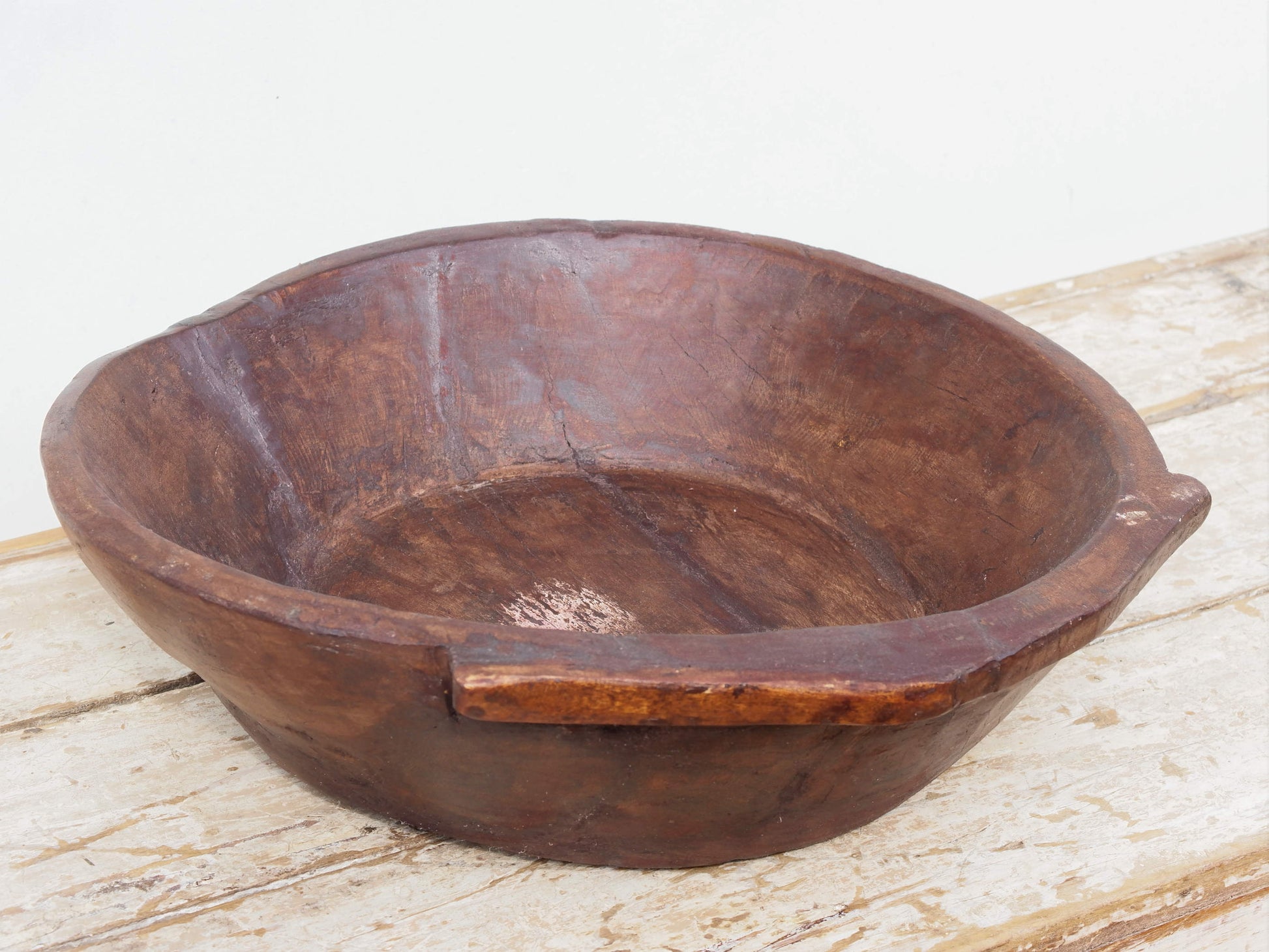 piatto in legno ricavato da un unico tronco di legno. usato in principio come piatto, setaccio per esiccare i cereali. tronco unico di teak massello databile inizio / metà 900.  dimensioni 49X47 h 13cm.