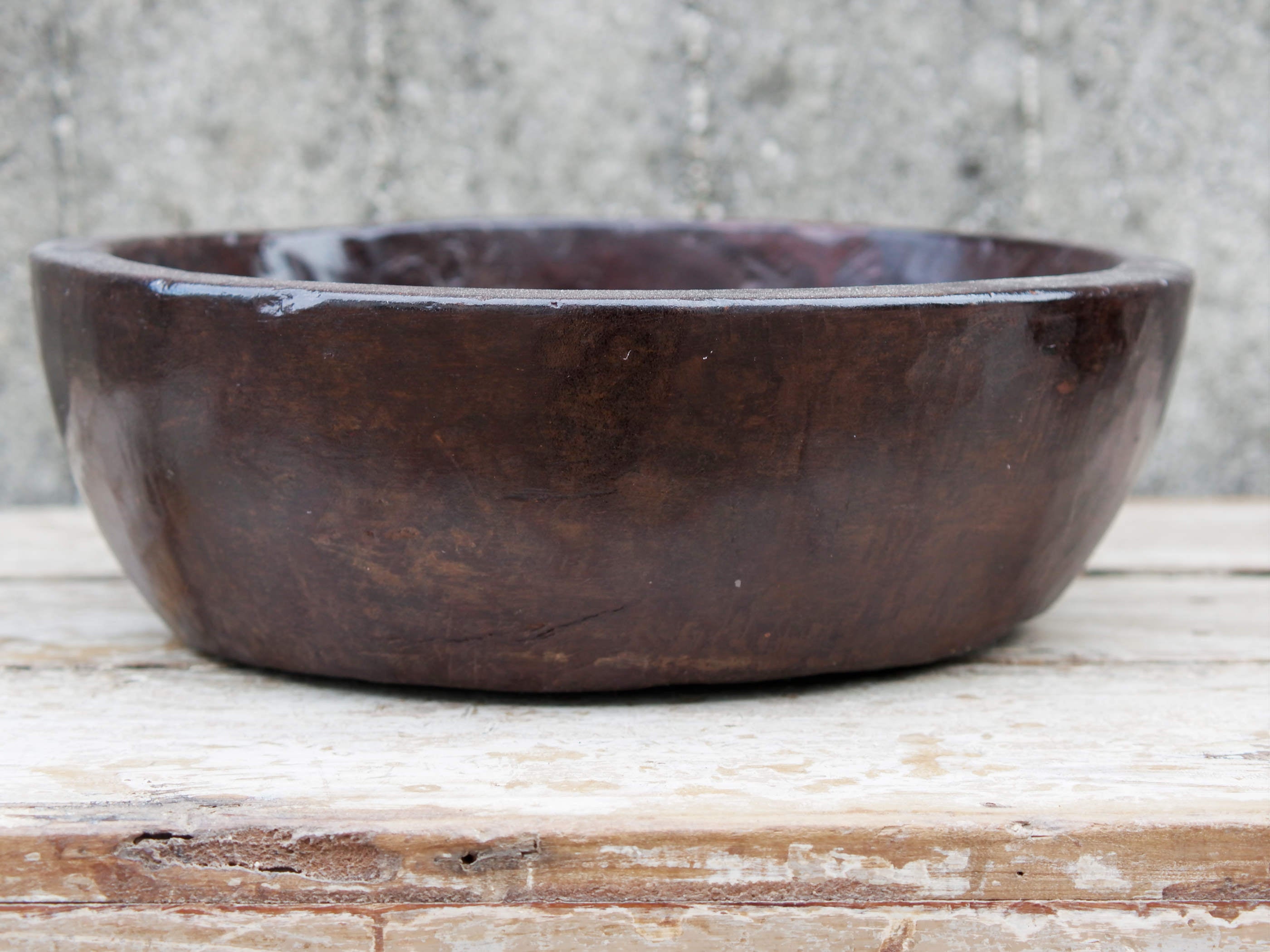 piatto in legno ricavato da un unico tronco di legno. usato in principio come piatto, setaccio per esiccare i cereali. tronco unico di teak massello databile inizio / metà 900.  dimensioni diametro 36 h 12cm.