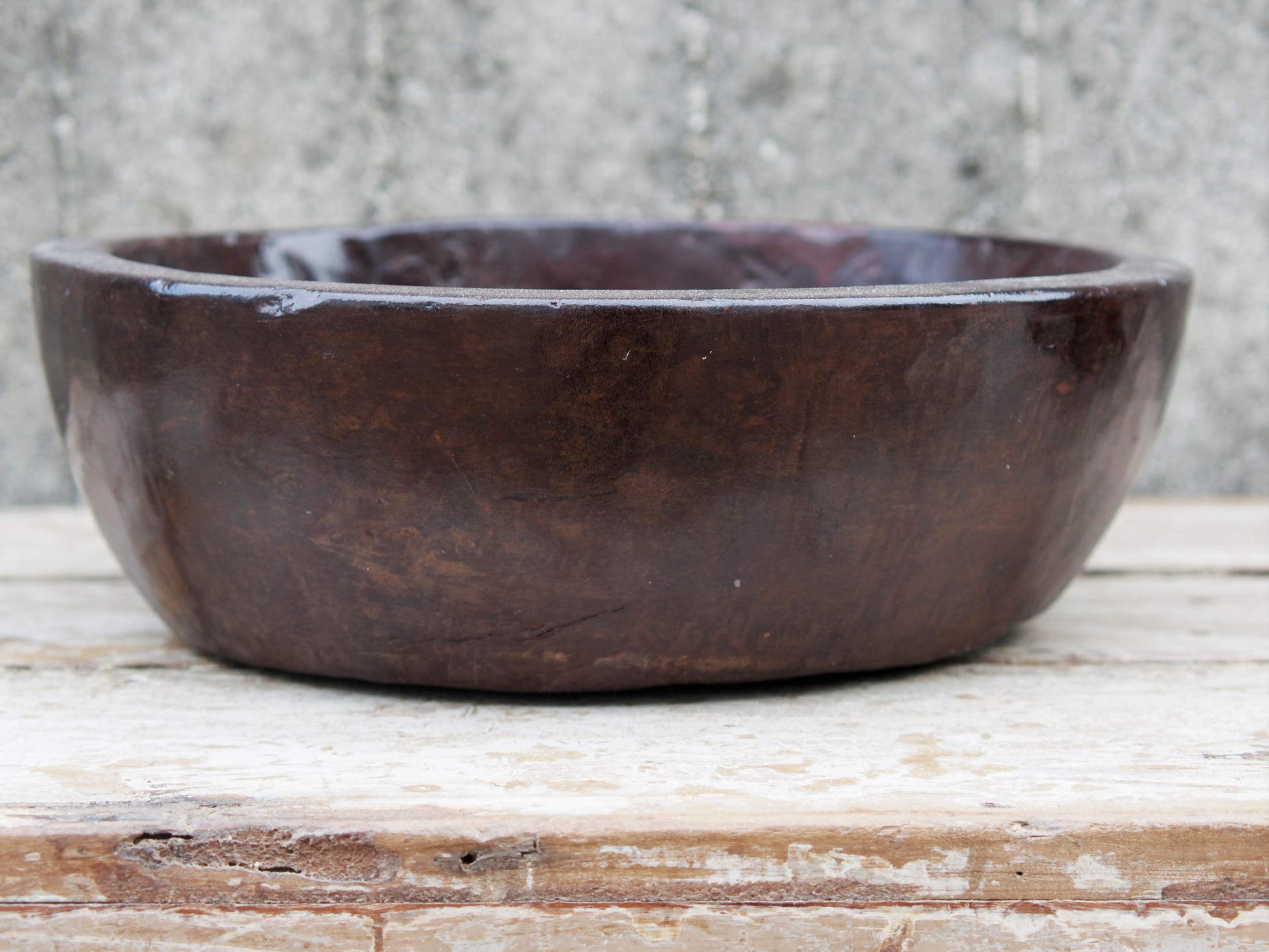 piatto in legno ricavato da un unico tronco di legno. usato in principio come piatto, setaccio per esiccare i cereali. tronco unico di teak massello databile inizio / metà 900.  dimensioni diametro 36 h 12cm.