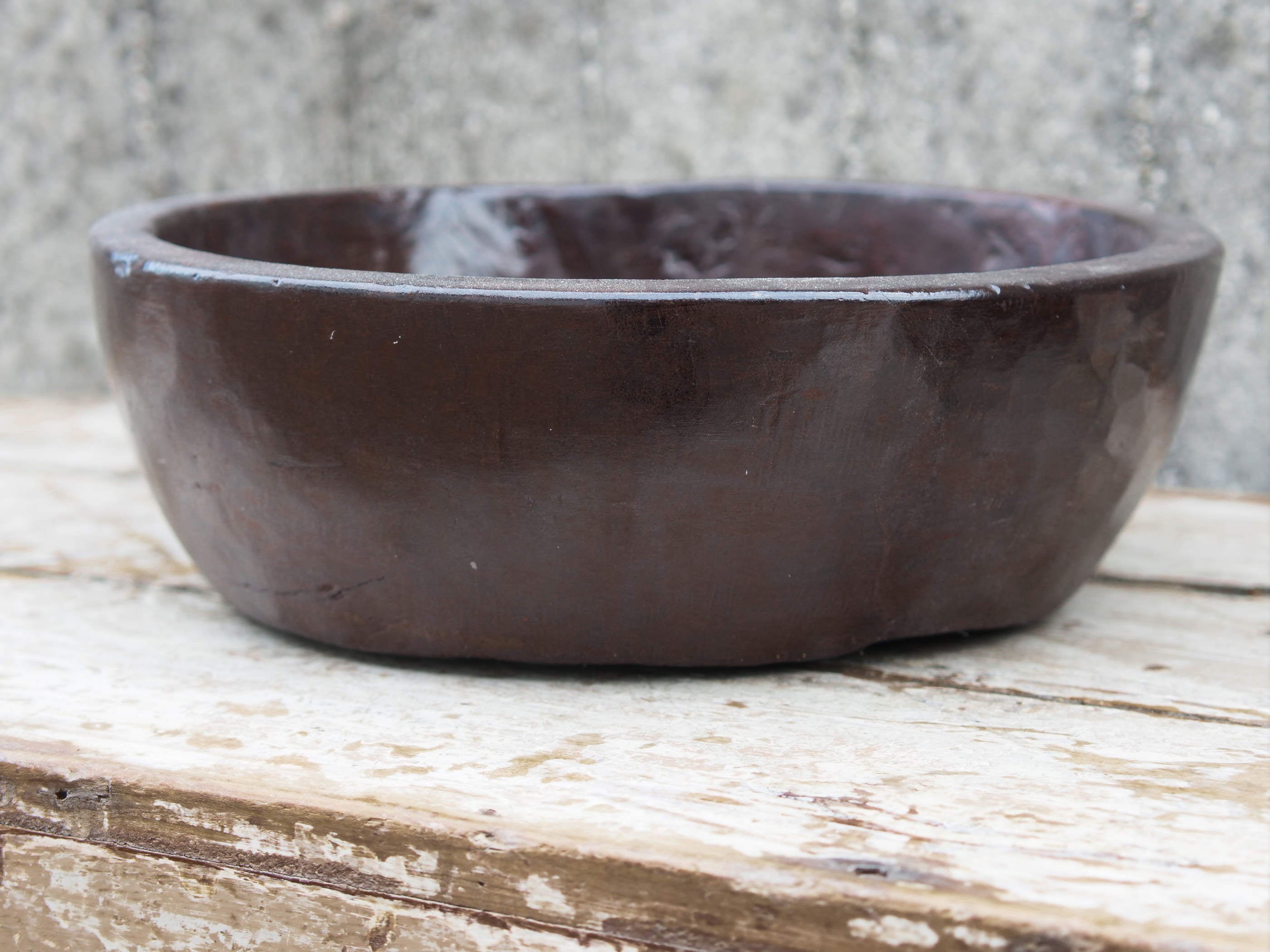 piatto in legno ricavato da un unico tronco di legno. usato in principio come piatto, setaccio per esiccare i cereali. tronco unico di teak massello databile inizio / metà 900.  dimensioni diametro 36 h 12cm.