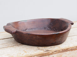 piatto in legno con manico ricavato da un unico tronco di legno con manici. usato in principio come piatto , setaccio per esiccare i cereali tronco unico di teak massello databile inizio / metà 900  dimensioni 47x42 h11cm.