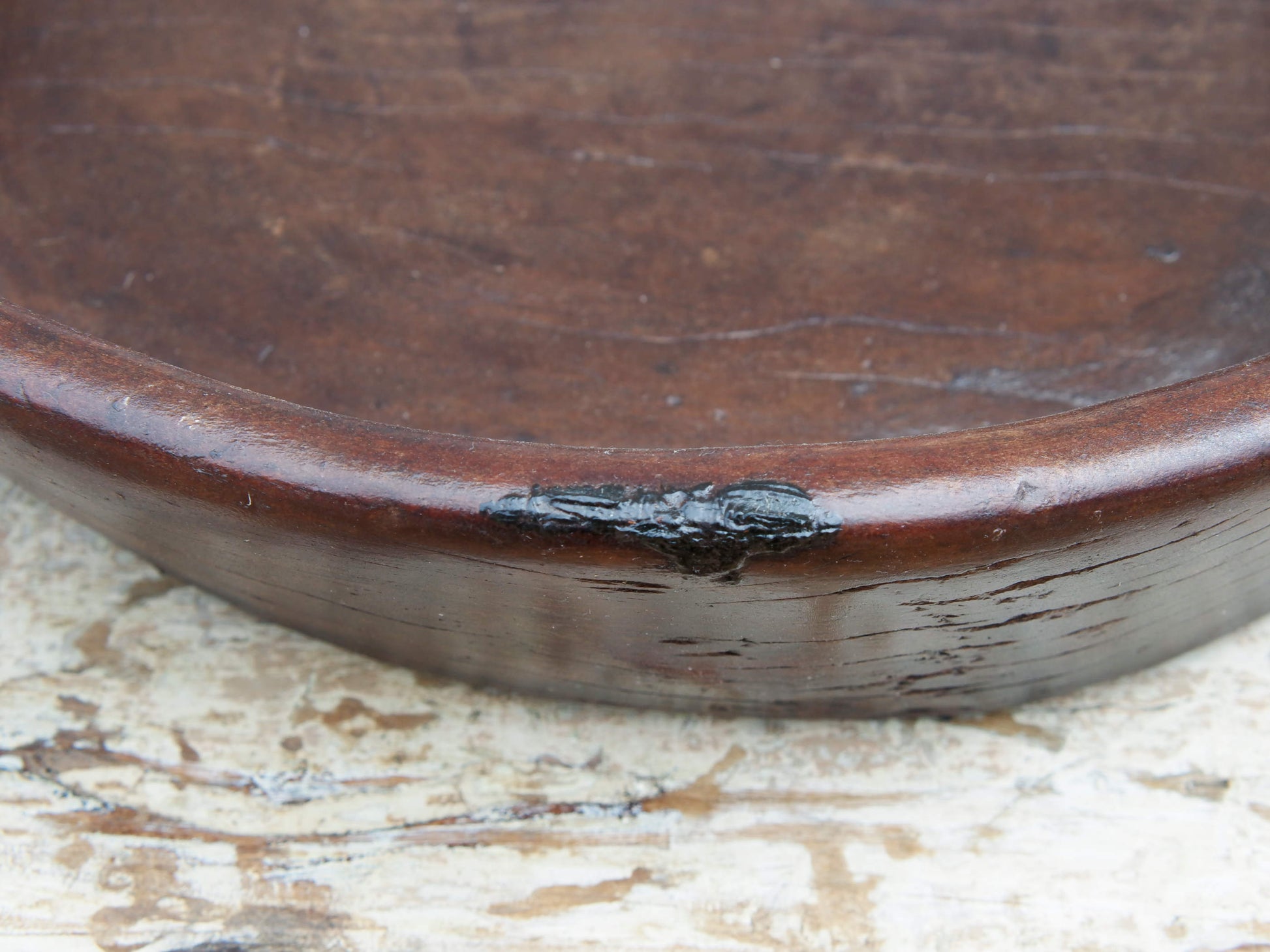 piatto in legno con manico ricavato da un unico tronco di legno con manici. usato in principio come piatto , setaccio per esiccare i cereali tronco unico di teak massello databile inizio / metà 900  dimensioni 47x42 h11cm.