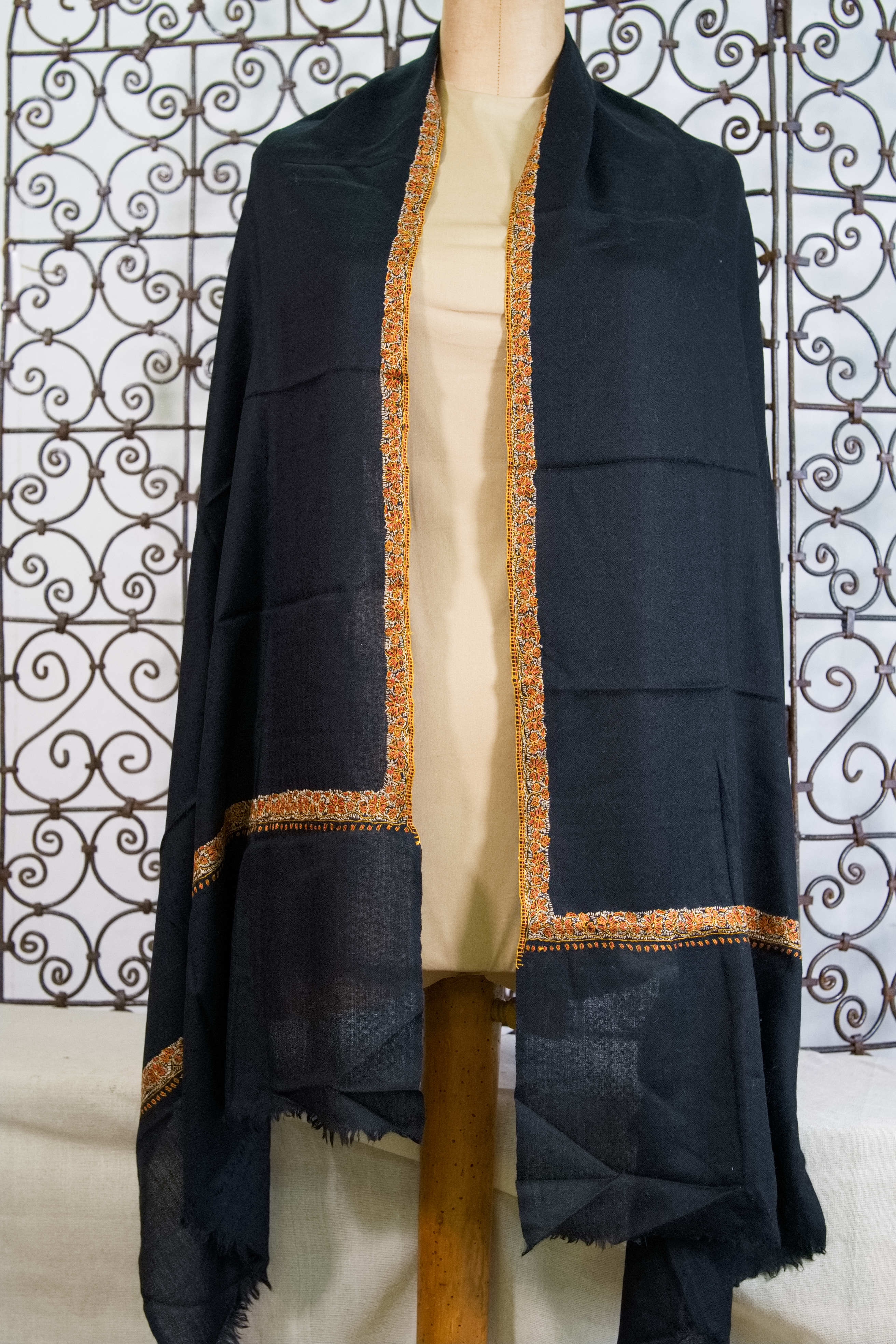 Inquadratura generale dello scialle nero in pashmina con ricami floreali chiari Neemdaur.