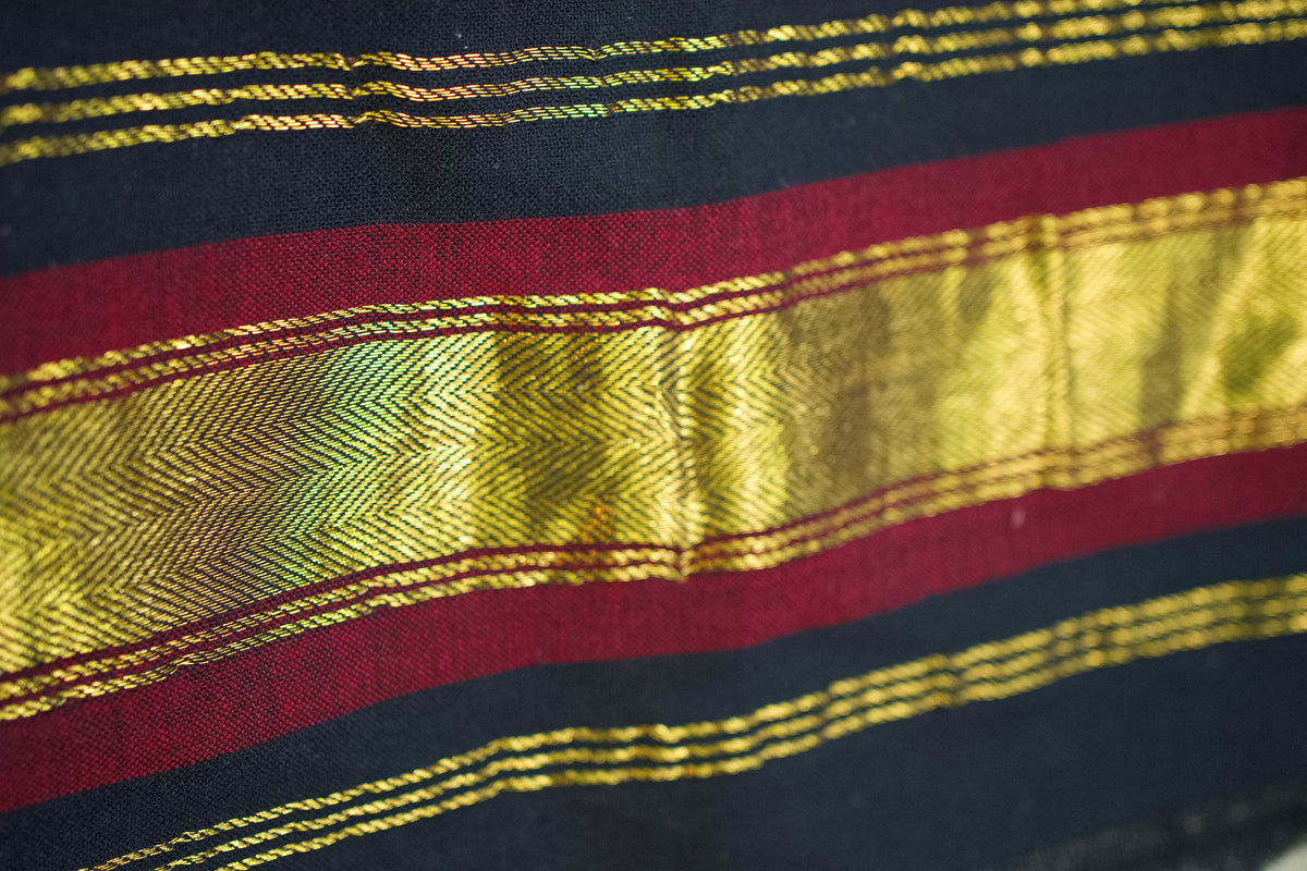 Particolare della fascia decorativa laterale con righe bordeaux e inserti metallici dorati.