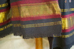Particolare della fascia decorativa laterale con righe bordeaux e inserti metallici dorati.