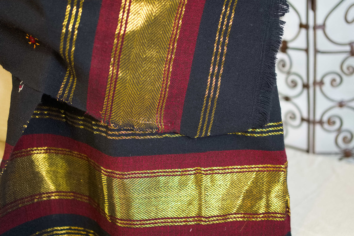 Particolare della fascia decorativa laterale con righe bordeaux e inserti metallici dorati.