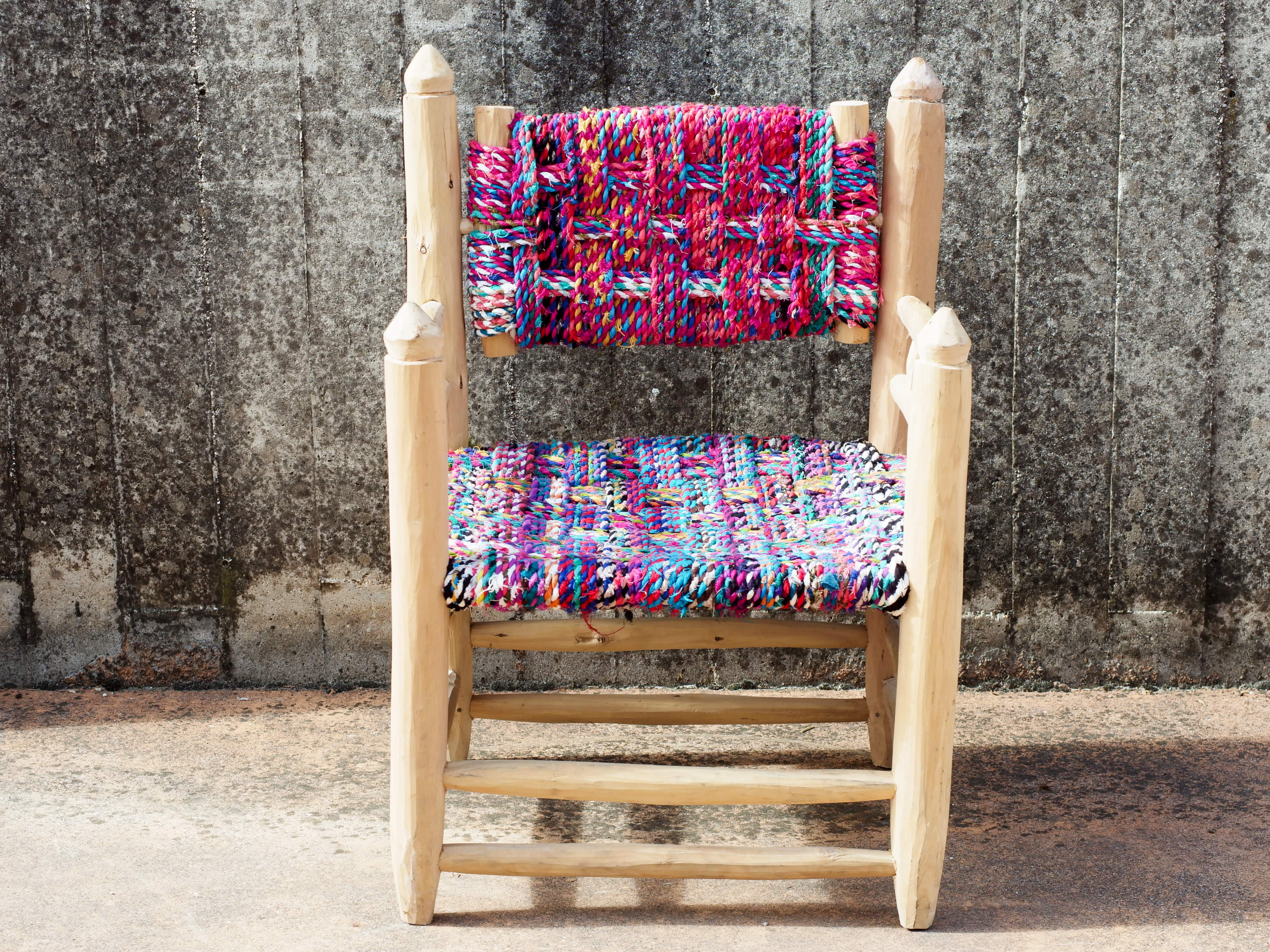Vista frontale della sedia intrecciata marocchina con seduta e schienale in cotone multicolor
