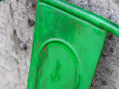 Dettaglio dei tubolari metallici ricurvi che compongono la struttura dello schienale verde.