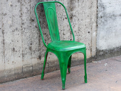 Angolazione prospettica della sedia vintage verde intesa come pezzo unico d'arredo.