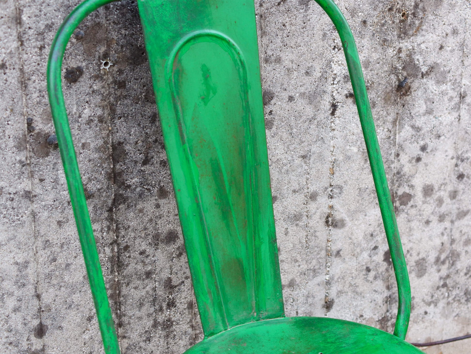 Dettaglio ravvicinato dello schienale sagolato in ferro e della laccatura verde sfumata.
