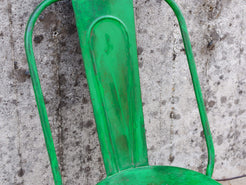 Dettaglio ravvicinato dello schienale sagolato in ferro e della laccatura verde sfumata.