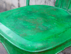 Particolare della seduta metallica verde con i segni caratteristici dell'usura artigianale.