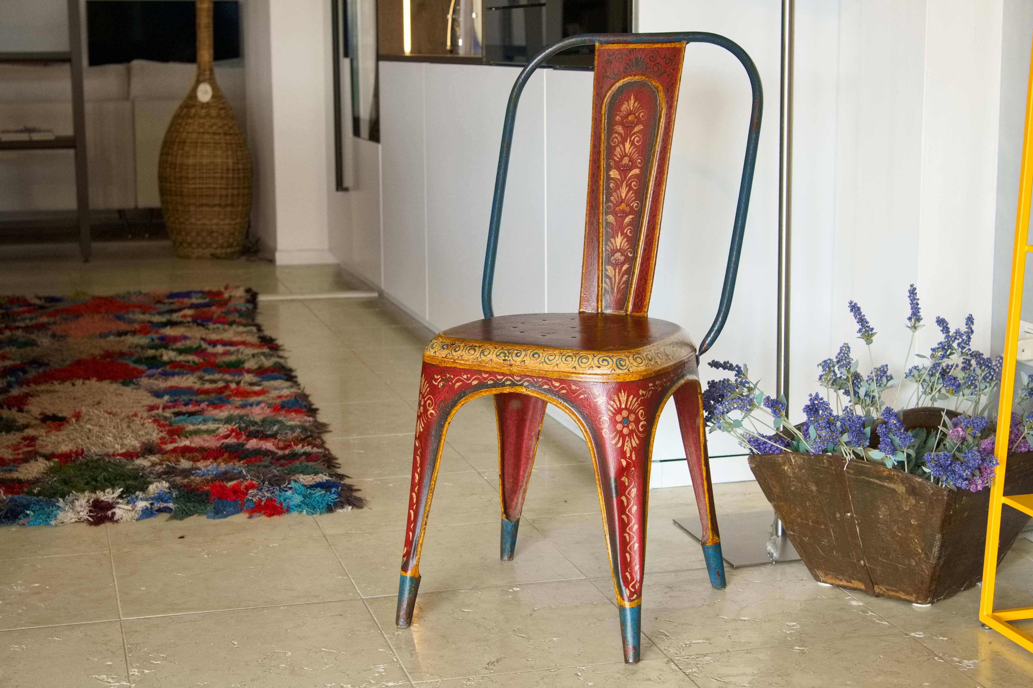 Vista frontale della sedia vintage in ferro con decorazioni floreali dipinte a mano
