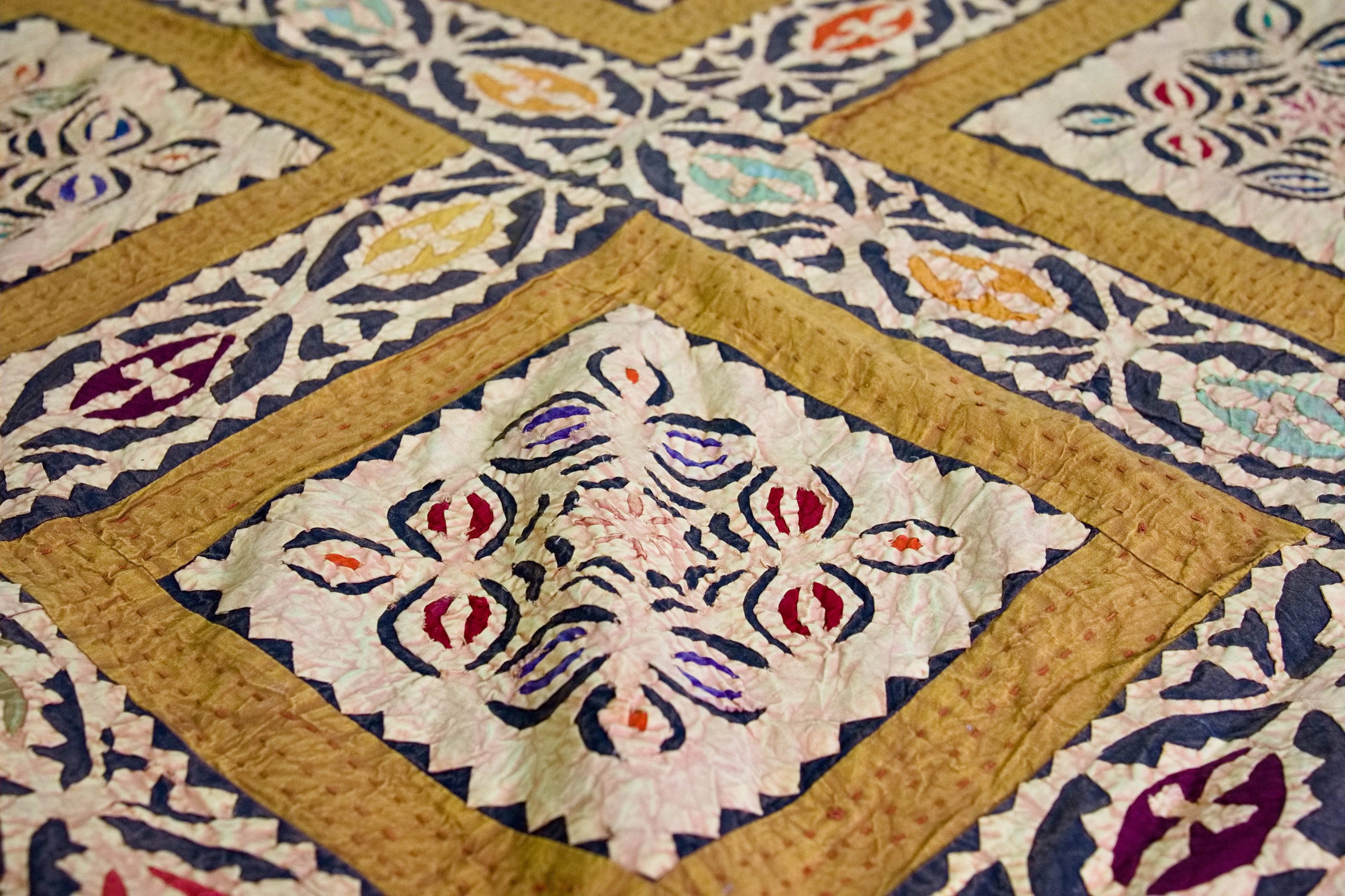 Dettaglio ravvicinato dei ricami floreali multicolore all'interno dei riquadri centrali.