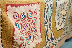 Dettaglio ravvicinato dei ricami floreali multicolore all'interno dei riquadri centrali.