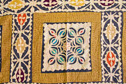 Dettaglio ravvicinato dei ricami floreali multicolore all'interno dei riquadri centrali.