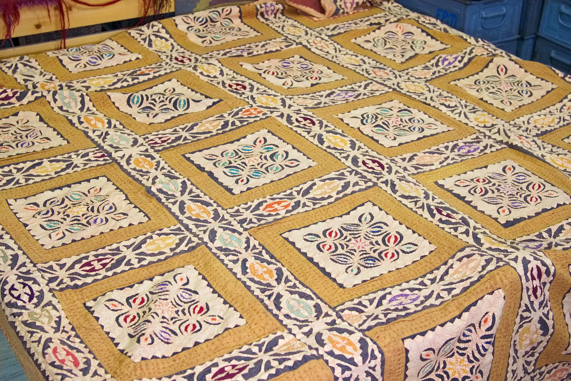Vista d'insieme del grande telo indiano in cotone con motivo a riquadri geometrici ocra e bianchi.