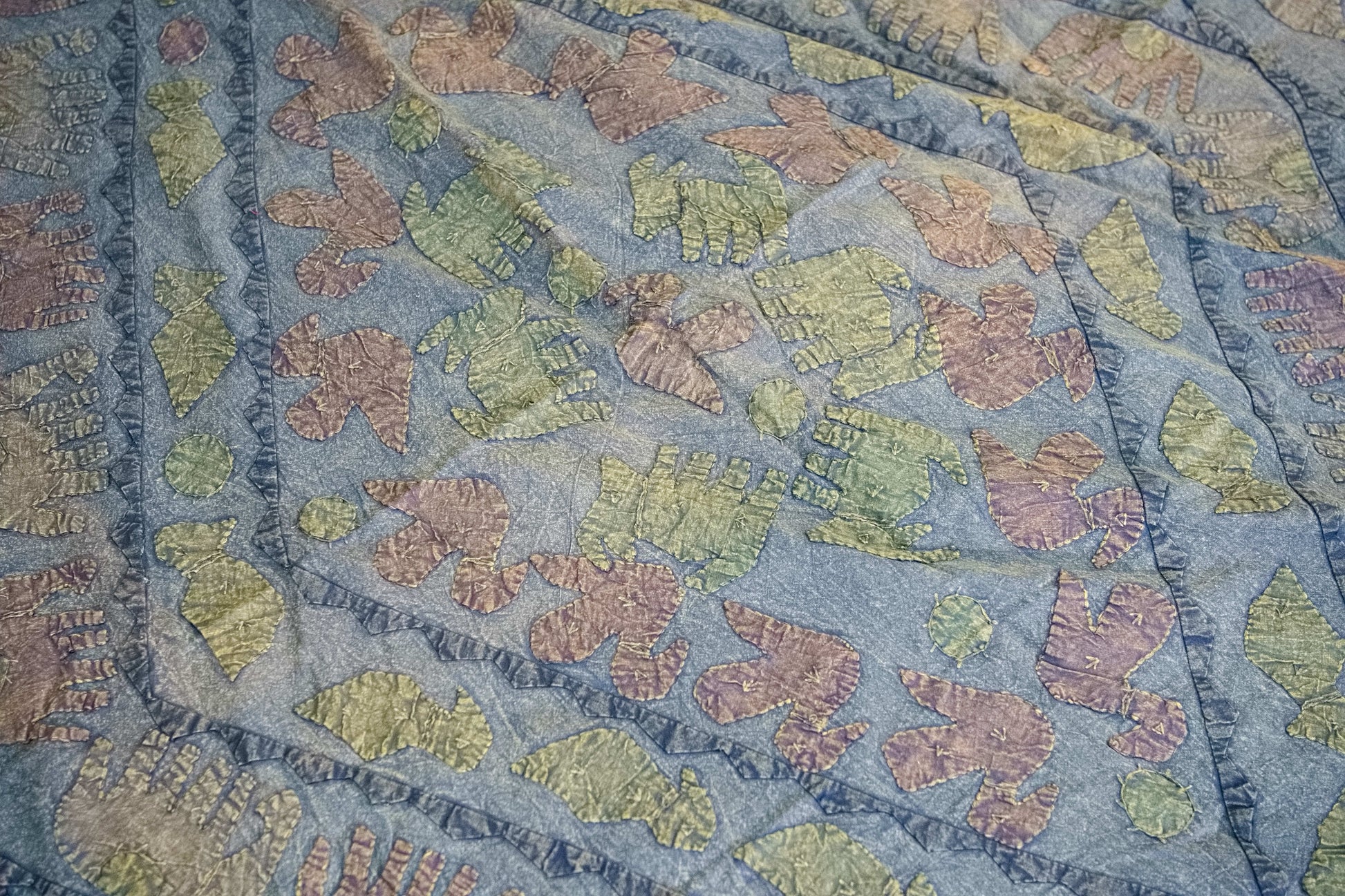 Dettaglio ravvicinato dei ricami artigianali colorati sulla superficie in cotone.