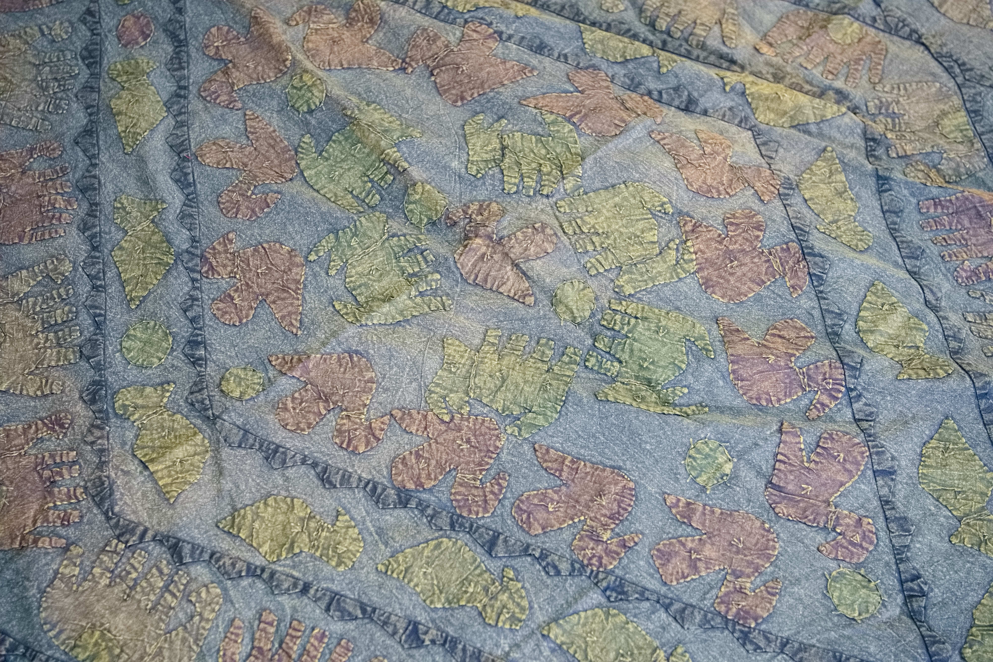 Dettaglio ravvicinato dei ricami artigianali colorati sulla superficie in cotone.