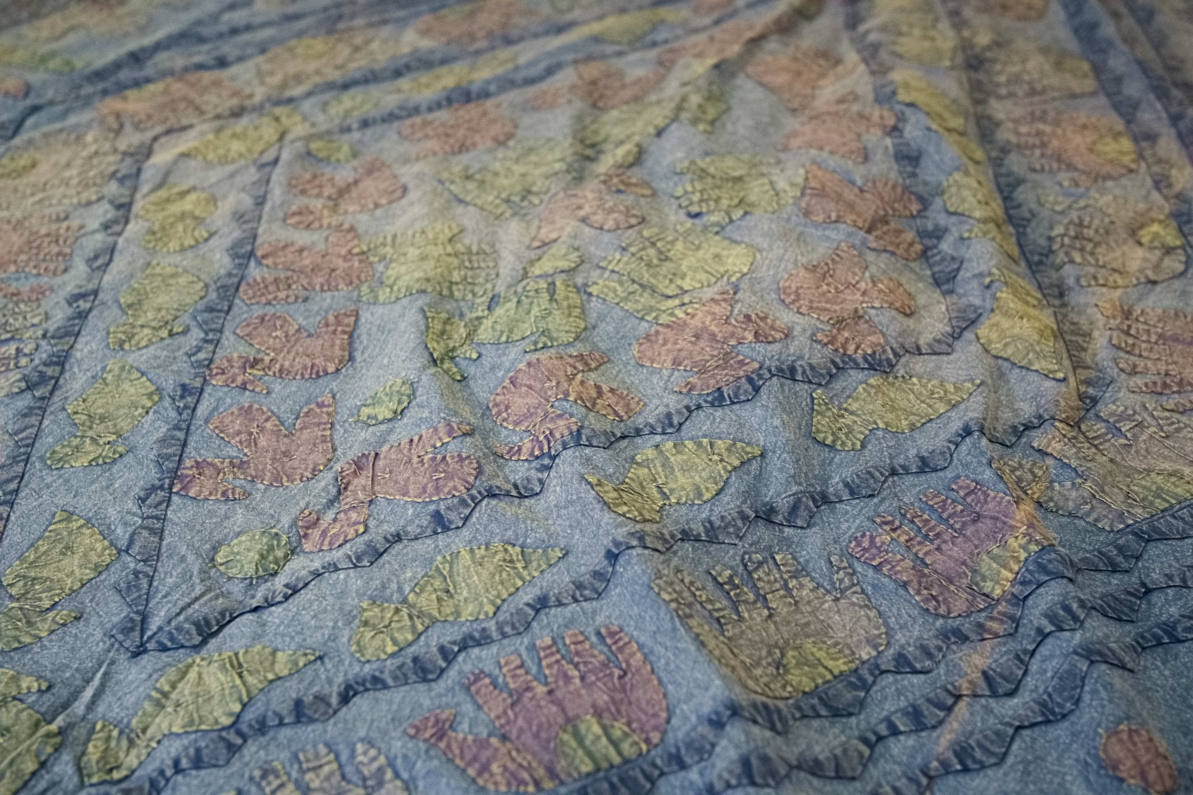 Dettaglio ravvicinato dei ricami artigianali colorati sulla superficie in cotone.