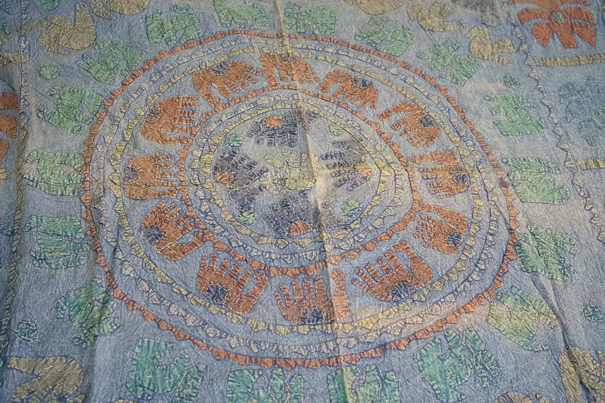 Dettaglio ravvicinato dei ricami artigianali colorati sulla superficie in cotone.