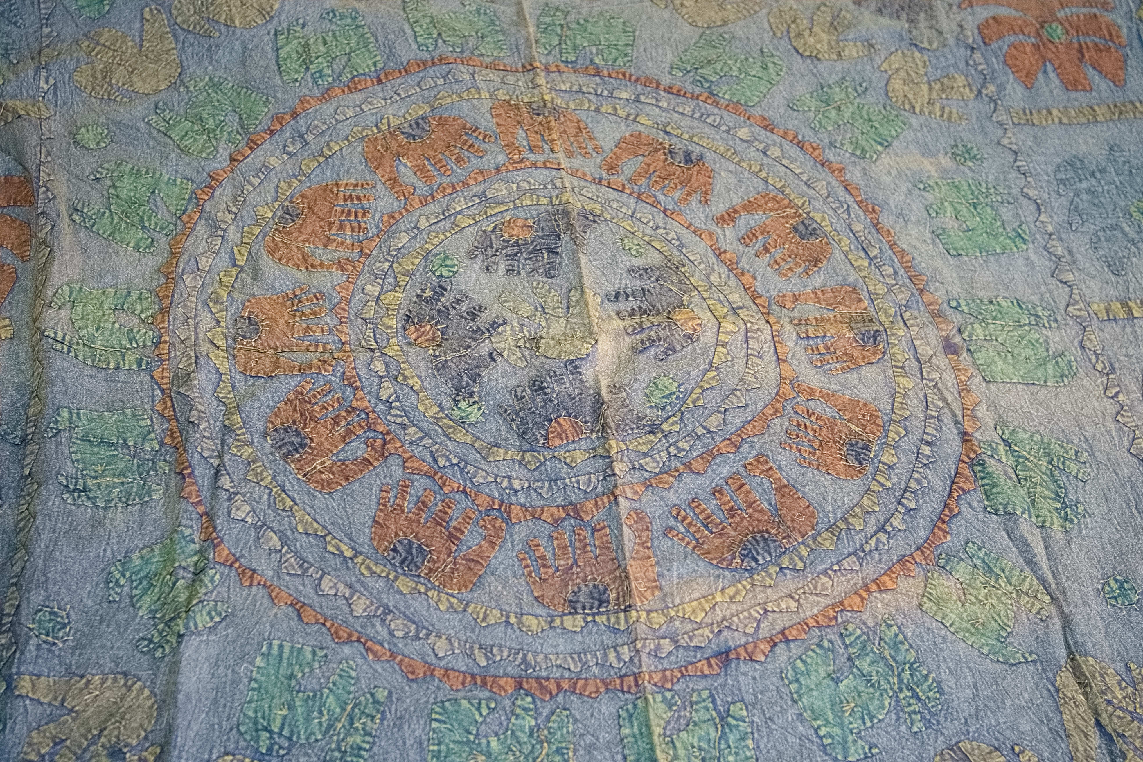 Dettaglio ravvicinato dei ricami artigianali colorati sulla superficie in cotone.