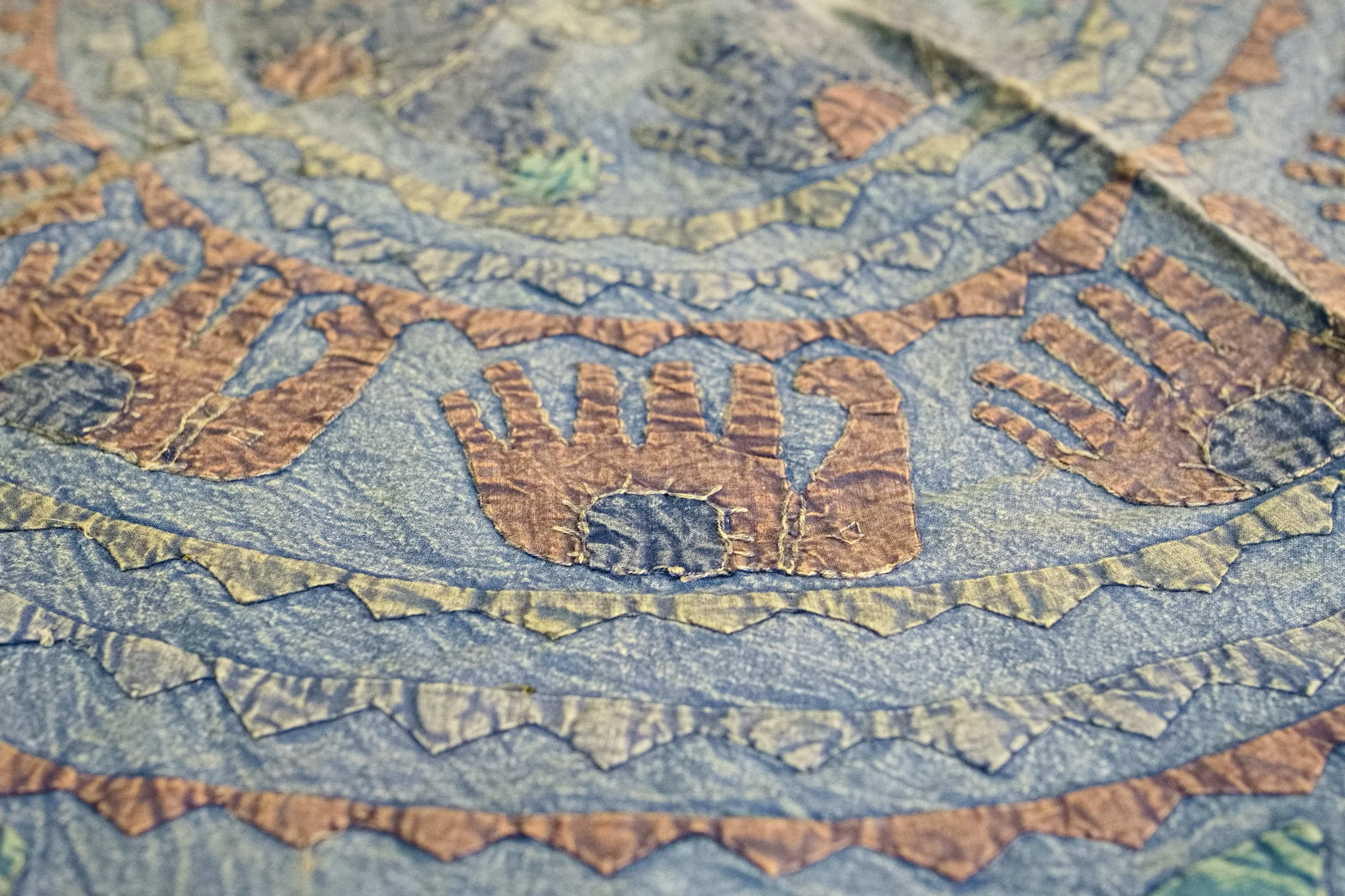 Dettaglio ravvicinato dei ricami artigianali colorati sulla superficie in cotone.
