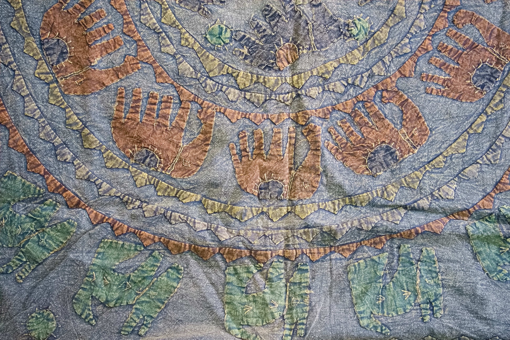 Dettaglio ravvicinato dei ricami artigianali colorati sulla superficie in cotone.