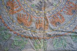 Dettaglio ravvicinato dei ricami artigianali colorati sulla superficie in cotone.
