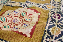 Dettaglio ravvicinato dei ricami floreali multicolore all'interno dei riquadri centrali.