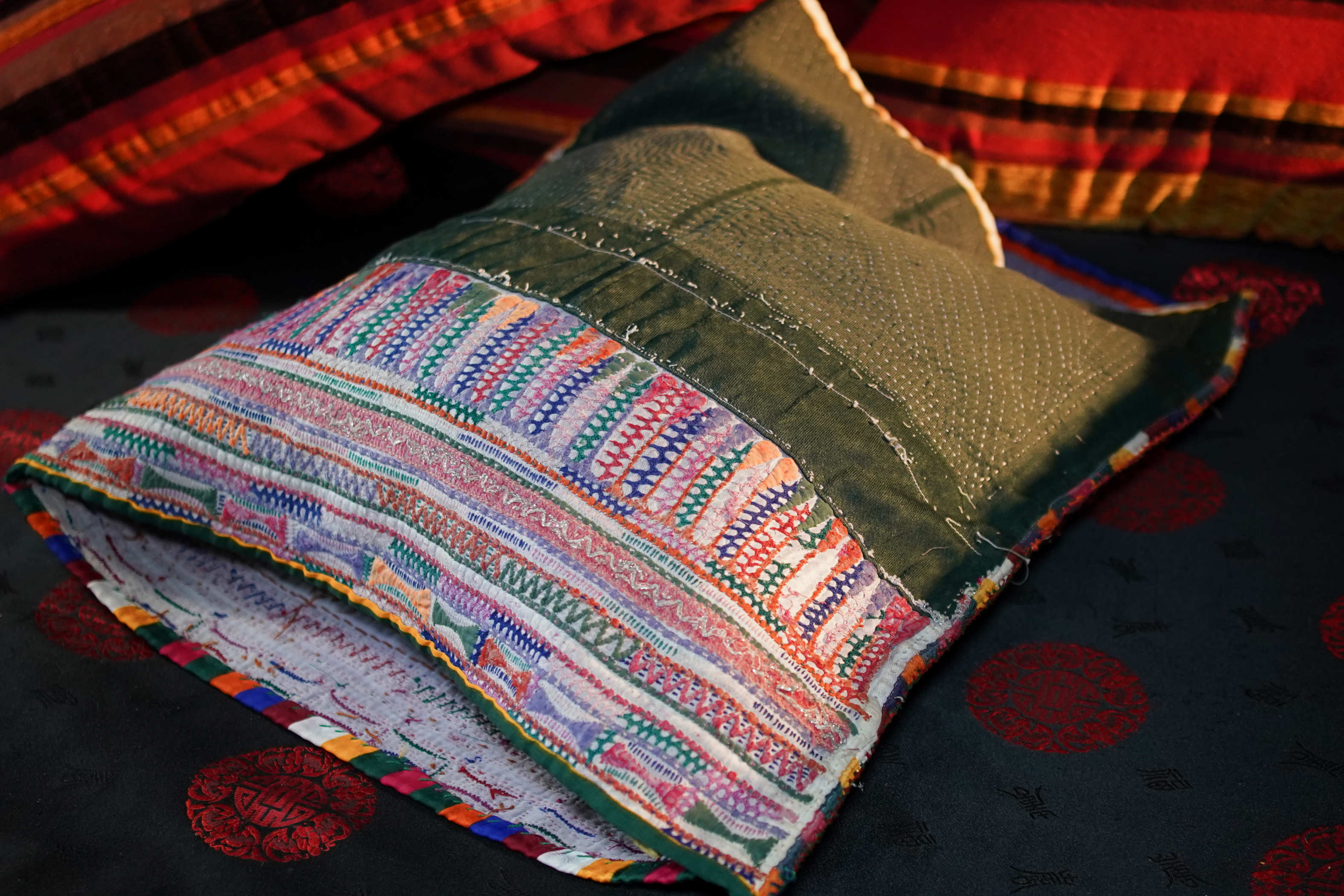 Vista d'insieme del tessuto antico indiano Kantha con base bordeaux e verde scuro.
