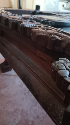 Dettaglio ravvicinato delle incisioni e dei simboli di buona sorte sullo schienale del trono.