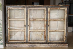 Vista frontale della vetrina indiana antica in teak laccato con tre ante.