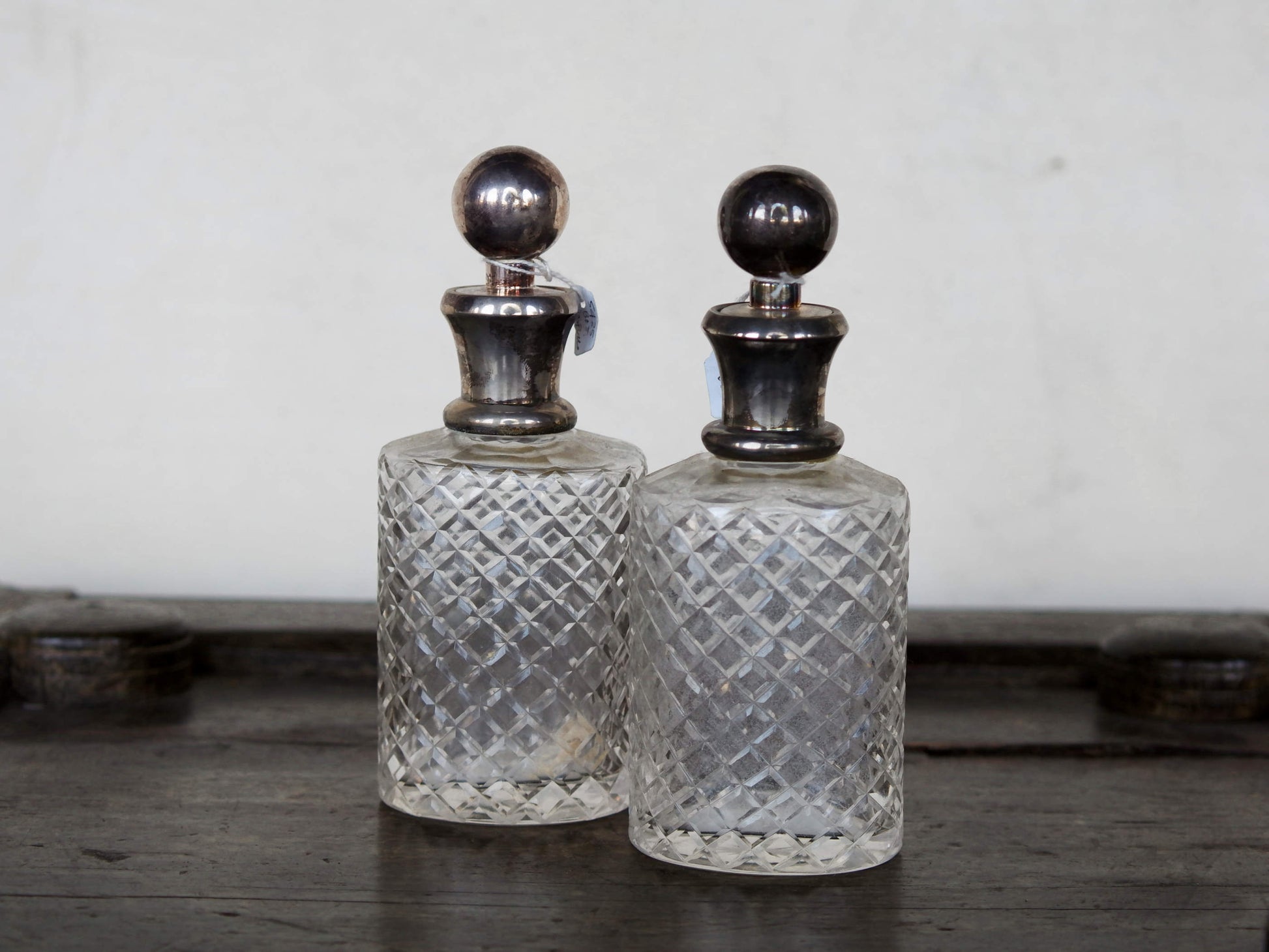 coppia vecchie bottiglie molate, incise, cesellate con tappo in argento.. si possono usare come oliera, bottiglietta per alcolici, porta aceto, vasetto per fiori, porta profumo, ecc... made in india, dimensioni diametro 7x6 h19cm.