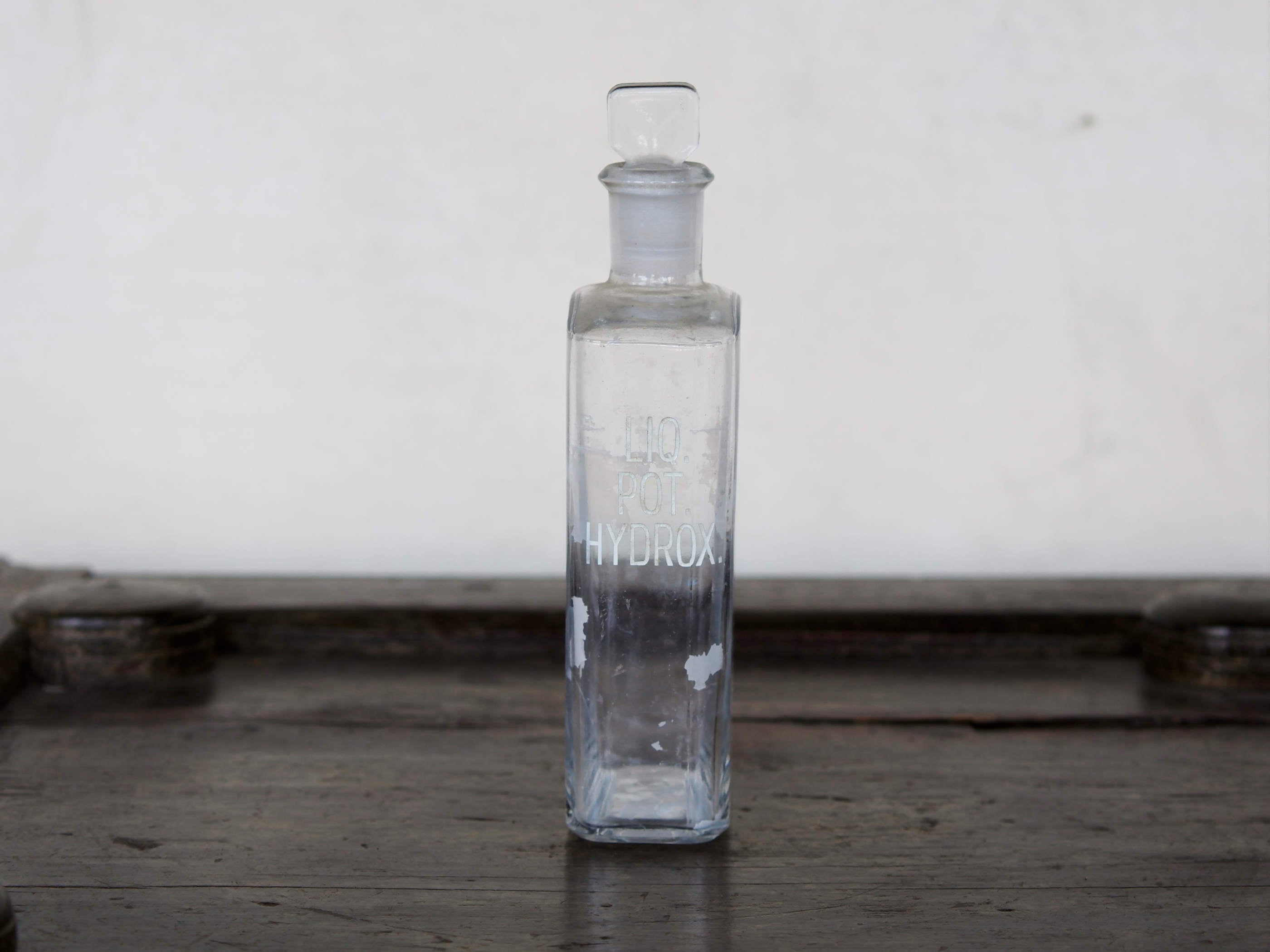Vecchia bottiglia da farmacia con tappo, bottiglia vintage trasparente, bottiglia chimica rettangolare con dicitura incisa. Lavorata artigialmente.  Dimensioni 4x7 h20cm.    per ulteriori info... mail info@etniko.it whatsapp 0039 3338778241 instagram, facebook, etsy : etnikobycrosato