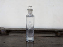 Carica l&#39;immagine nel visualizzatore di Gallery, Vecchia bottiglia da farmacia con tappo, bottiglia vintage trasparente, bottiglia chimica rettangolare con dicitura incisa. Lavorata artigialmente.  Dimensioni 4x7 h20cm.    per ulteriori info... mail info@etniko.it whatsapp 0039 3338778241 instagram, facebook, etsy : etnikobycrosato