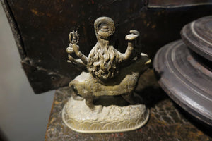 statuetta di Durga indiana in metallo inciso artigianalmente .   Presso la religione induista  "colei che difficilmente si può avvicinare" è una forma di Devi , ovvero della Madre Divina (che assume anche molte altre forme, tra cui Sarasvati , Parvati, Lakshmi, Kālī). È raffigurata come una donna che cavalca un leone, sebbene più raramente la si trovi raffigurata anche su una tigre, con numerose braccia mani che impugnano diversi tipi di armi e fanno dei mudrā (gesti simbolici fatti con la mano). Questa for