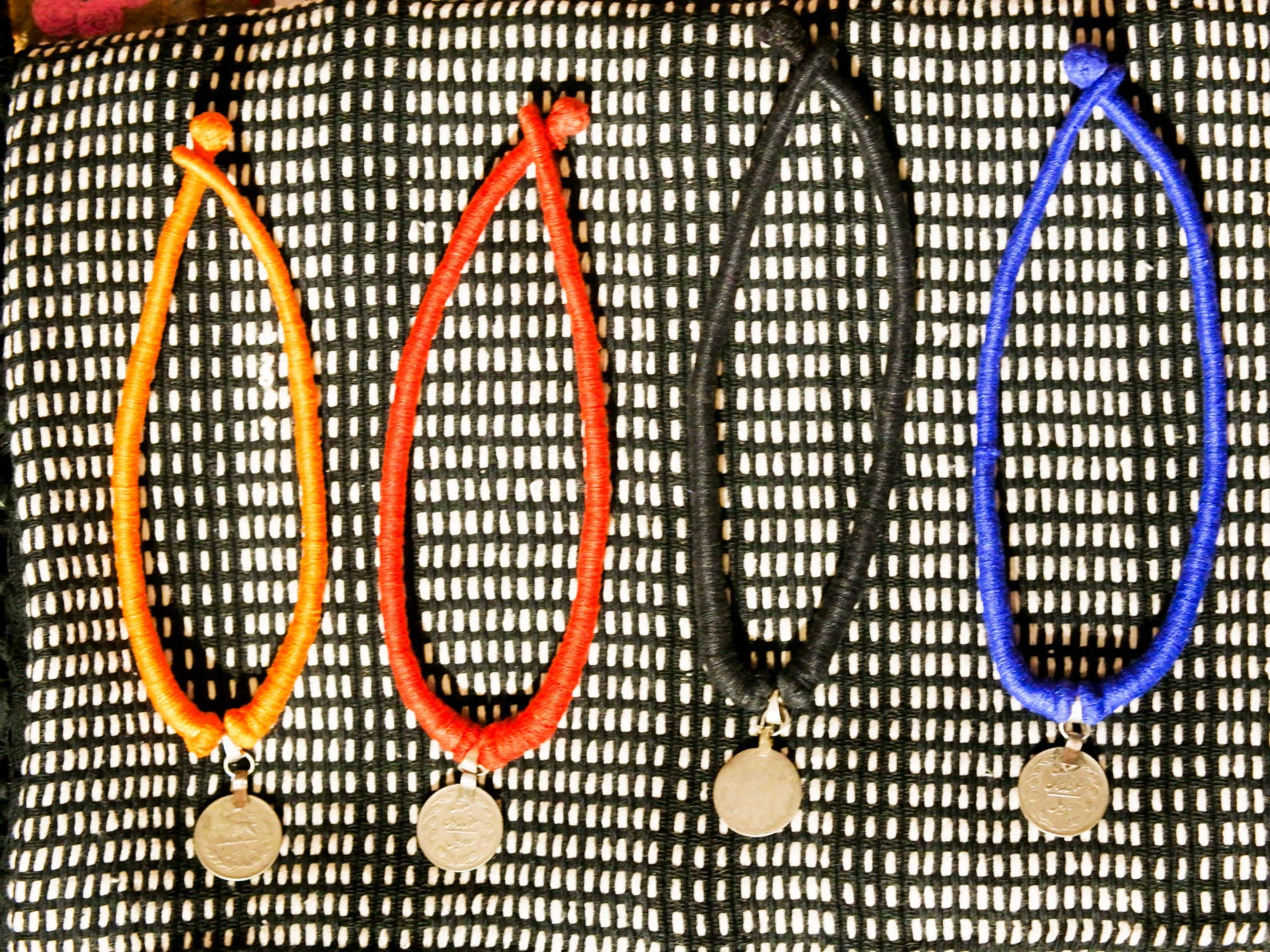 collane in cotone intrecciato con pendaglio  moneta antica afgana con scrittura araba .  pezzi unici con pendaglio riciclato .  ulteriori info e foto contattare .
