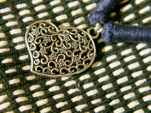collane in cotone intrecciato con pendaglio cuori in metallo inossidabile cesellato e lavorato a sbalzo , traforato pezzi unici con pendaglio riciclato .