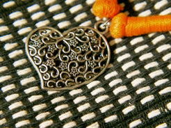collane in cotone intrecciato con pendaglio cuori in metallo inossidabile cesellato e lavorato a sbalzo , traforato pezzi unici con pendaglio riciclato .