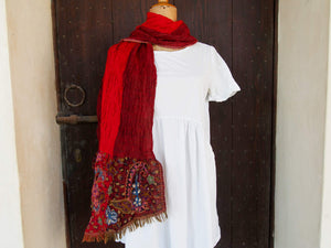 scialle in lana ricamato . lana elasticizzata , ricamo a mano a tema floreale .  più disegno tinto in filo in tramatura 