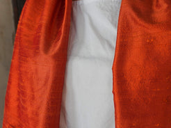 Scialle indiano in shantung di seta , un tessuto di seta selvaggia, di colore unito, caratterizzato da una superficie ruvida, molto irregolare e dall'aspetto grezzo di colore arancione.