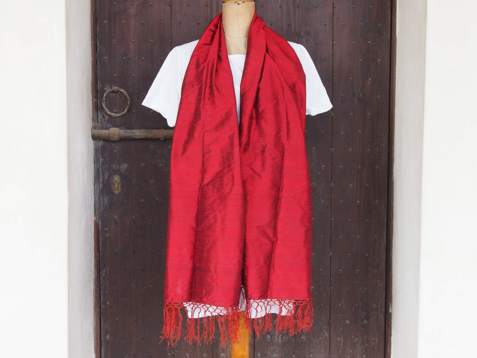Scialle indiano in shantung di seta , un tessuto di seta selvaggia, di colore unito, caratterizzato da una superficie ruvida, molto irregolare e dall'aspetto grezzo di colore rosso.