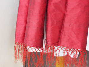 Scialle indiano in shantung di seta , un tessuto di seta selvaggia, di colore unito, caratterizzato da una superficie ruvida, molto irregolare e dall'aspetto grezzo di colore rosso.