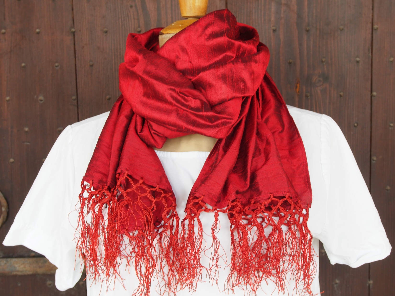 Scialle indiano in shantung di seta , un tessuto di seta selvaggia, di colore unito, caratterizzato da una superficie ruvida, molto irregolare e dall'aspetto grezzo di colore rosso.